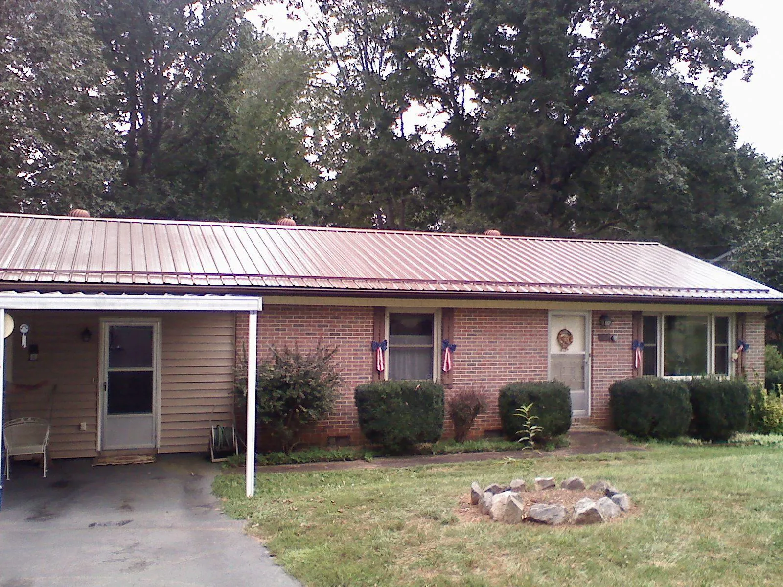 Bronze metal roof and carport on a brick ranch home — Roof Repair work by our crew in Rootstown